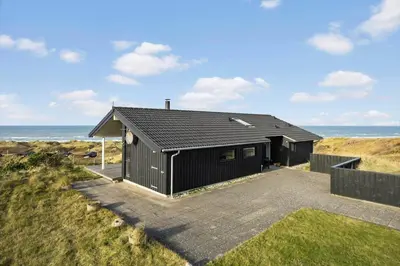 a black building with the ocean in the background at LK611-Lokken-Rosavej-9 in Løkken