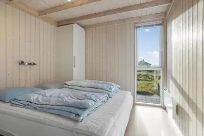 a bedroom with two pillows on a bed with a window at LK611-Lokken-Rosavej-9 in Løkken