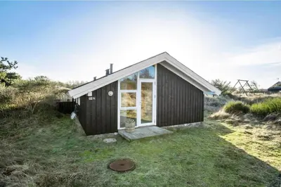 a small house with a large window on a field at BL1414-Saltum-Porsevej-18-A in Saltum