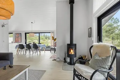 a living room with a fireplace and a table at BL1635-Blokhus-Lyngdraget-19 in Blokhus