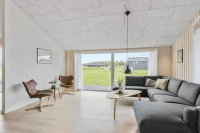 a living room with a couch and a table and chairs at LK2031-Lokken-Kringelbaekvej-55 in Løkken
