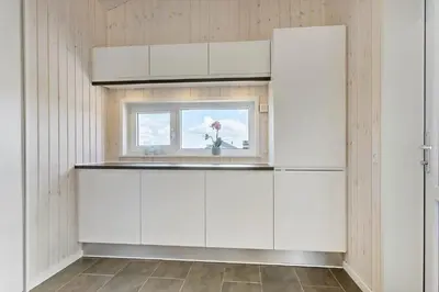 a kitchen with white cabinets and a window at LK2031-Lokken-Kringelbaekvej-55 in Løkken