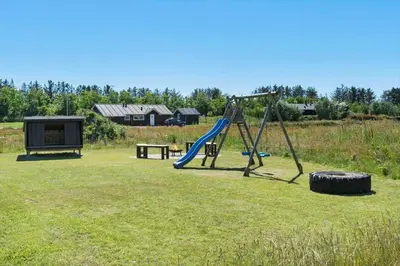 a playground with a slide and a playption in a field at LK2031-Lokken-Kringelbaekvej-55 in Løkken