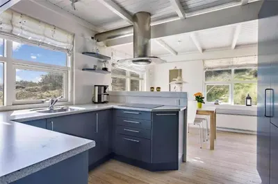 a large kitchen with blue cabinets and a sink at BL116-Saltum-Revlingevej-44 in Saltum
