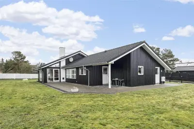 a black and white house with a large yard at BL1629-Blokhus-Klitgaardsvej-29 in Blokhus