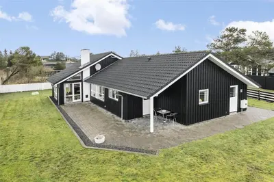 a black house with a black roof at BL1629-Blokhus-Klitgaardsvej-29 in Blokhus