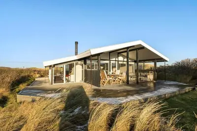 a house with a wooden deck in a field at BL1265-Saltum-Faaborgvej-7 in Saltum