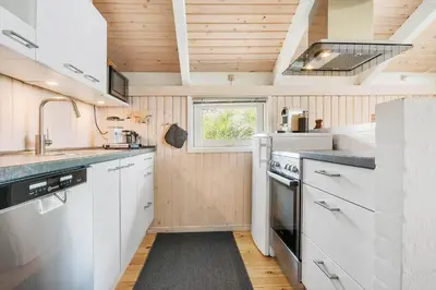 a kitchen with white cabinets and a window at BL416-Saltum-Revlingevej-28 in Saltum