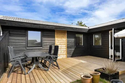 a patio with a table and chairs on a deck at LK2117-Lokken-Kettrup-Bjerge-Vej-55 in Løkken