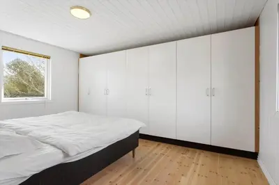 a bedroom with white cabinets and a bed at LK2117-Lokken-Kettrup-Bjerge-Vej-55 in Løkken