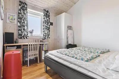 a bedroom with a bed and a desk and a window at BL1333-Pandrup-Hunetorp-Klitvej-109 in Pandrup