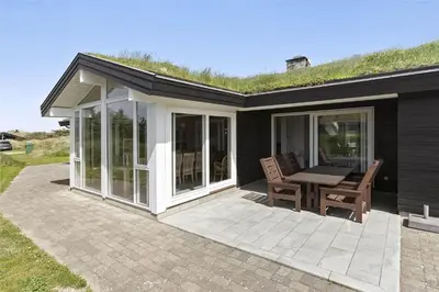 a house with a patio with a table and chairs at BL1333-Pandrup-Hunetorp-Klitvej-109 in Pandrup