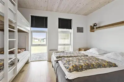 a bedroom with two bunk beds and two windows at BL1333-Pandrup-Hunetorp-Klitvej-109 in Pandrup