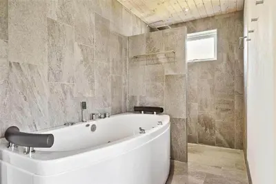 a bathroom with a large white tub in a room at BL1333-Pandrup-Hunetorp-Klitvej-109 in Pandrup
