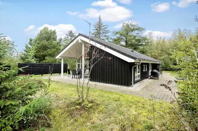 a black and white house in a garden at BL1764-Pandrup-Lunekrogen-7 in Pandrup