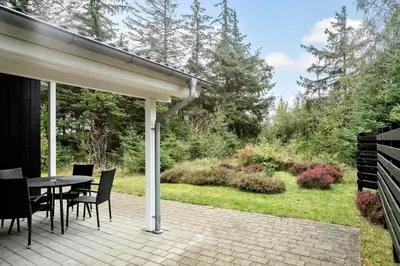 a patio with a table and chairs and a garden at BL1764-Pandrup-Lunekrogen-7 in Pandrup
