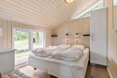 a bedroom with a bed in a room with a window at BL1764-Pandrup-Lunekrogen-7 in Pandrup