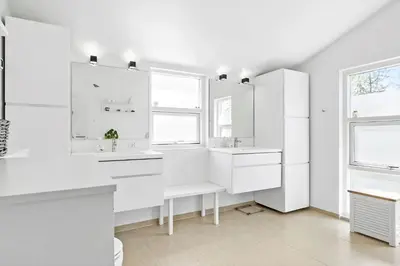 a white kitchen with white cabinets and windows at BL1598-Blokhus-Raevestien-2 in Blokhus