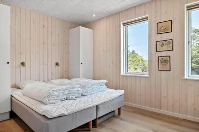 a bedroom with a bed and two windows at LK2116-Lokken-Marthasvej-5-C in Løkken