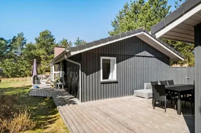 a house with a wooden deck with a table at BL1131-Saltum-Daadyrvej-11 in Saltum