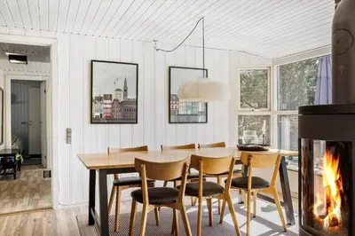 a dining room with a table and chairs and a fireplace at BL1131-Saltum-Daadyrvej-11 in Saltum