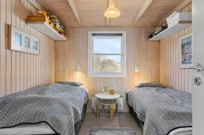 two beds in a room with a table and a window at BL771-Saltum-Egernvej-36 in Saltum