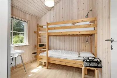 a bedroom with two bunk beds in a wooden wall at BL704-Blokhus-Soren-Petersvej-7 in Blokhus