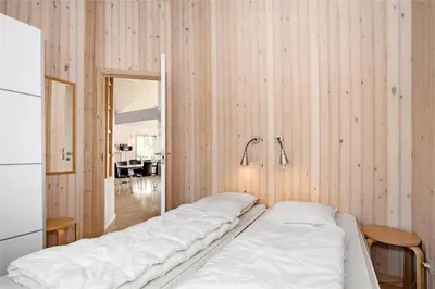 a bedroom with two beds in a room with wooden walls at BL704-Blokhus-Soren-Petersvej-7 in Blokhus
