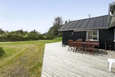a wooden deck with a table and chairs on it at BL704-Blokhus-Soren-Petersvej-7 in Blokhus