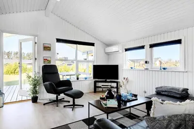 a living room with a couch and a tv at LK2141-Lokken-Kristavej-15 in Løkken