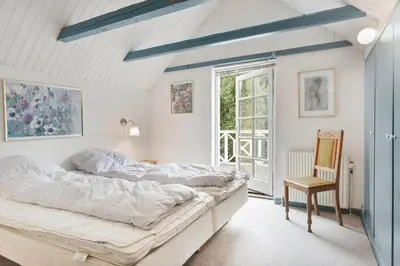 a bedroom with two beds and a chair in it at BL367-Pandrup-Rodhus-Kirkevej-5 in Pandrup