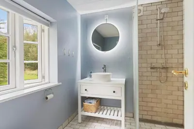 a bathroom with a sink and a shower with a mirror at BL367-Pandrup-Rodhus-Kirkevej-5 in Pandrup
