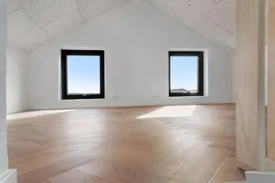 an empty room with two windows and a wooden floor at LK2143-Lokken-Kringelbaekvej-29 in Løkken
