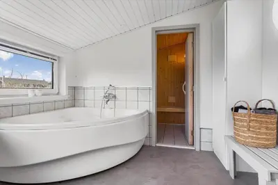 a large white bath tub in a bathroom with a window at LK2126-Lokken-Jorginesvej-4 in Løkken