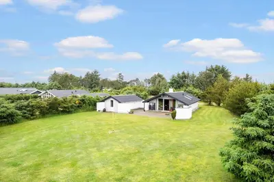 a large yard with a house in the background at BL1309-Blokhus-Quintusvej-22 in Blokhus