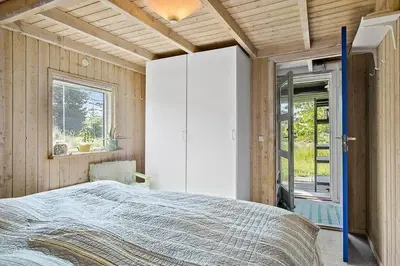 a bedroom with a large bed and a window at BL1235-Blokhus-Malinsvej-9 in Blokhus