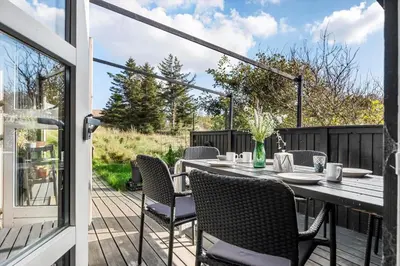 a patio with a table and chairs on a deck at BL1235-Blokhus-Malinsvej-9 in Blokhus