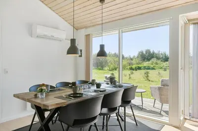 a dining room with a table and chairs and a large window at BL512-Saltum-Trehoje-2 in Saltum