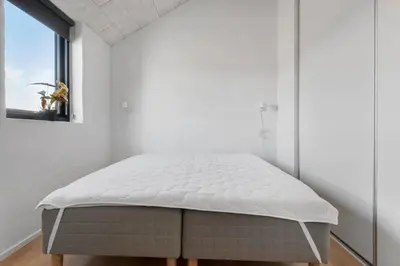 a bed in a white room with a window at LK2144-Lokken-Kringelbaekvej-31 in Løkken