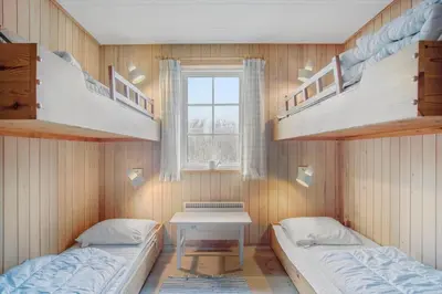 two bunk beds in a room with a table and a window at BL1241-Saltum-Bondagervej-2 in Saltum