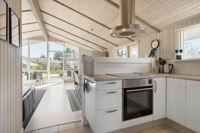a kitchen with white cabinets and a stove top oven at BL1706-Blokhus-Bloksbjerg-91 in Blokhus