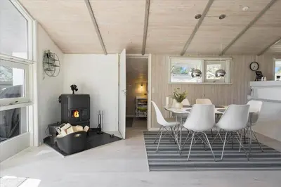 a living room with a table and chairs and a fireplace at BL1706-Blokhus-Bloksbjerg-91 in Blokhus