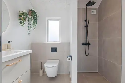a bathroom with a shower and a toilet and a sink at LK2146-Lokken-Redningsstien-2 in Løkken