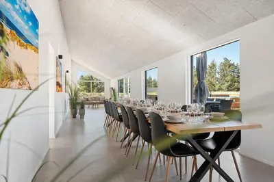 a dining room with a long table and chairs at LK2146-Lokken-Redningsstien-2 in Løkken