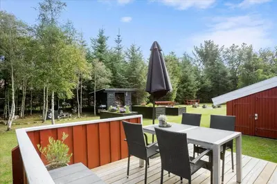 a patio with a table and chairs and an umbrella at BL1092-Saltum-Doggerbanke-2 in Saltum