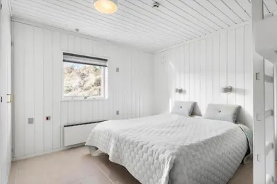 a white bedroom with a bed and a window at BL1349-Pandrup-Rodhus-Klitvej-217 in Pandrup