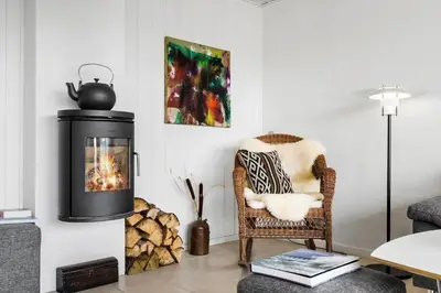 a living room with a fireplace and a chair at BL1349-Pandrup-Rodhus-Klitvej-217 in Pandrup