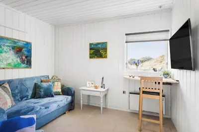 a living room with a blue couch and a window at BL1349-Pandrup-Rodhus-Klitvej-217 in Pandrup