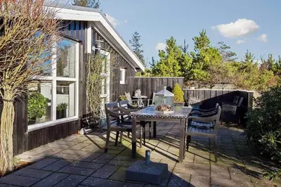 a patio with a table and chairs and a fence at BL1258-Blokhus-Frederiksensvej-19 in Blokhus