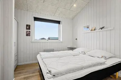 a bedroom with a large bed with a window at LK2167-Lokken-Kringelbaekvej-12 in Løkken
